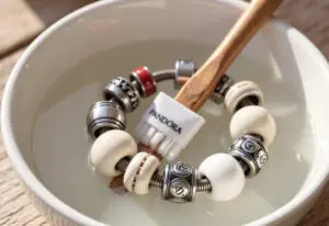 prikaz kako očistiti pandora nakit z nežnim namakanjem v milnici in mehko krtačko