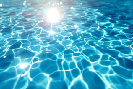 močna sončna svetloba ki osvetljuje čisto vodo v bazenu kar je naraven način kako zmanjšati klor v bazenu